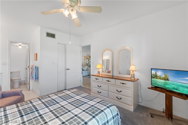 tiled bedroom with ceiling fan, a closet, and ensuite bathroom