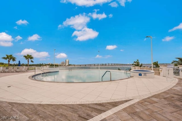 view of swimming pool featuring a patio area and an in ground hot tub