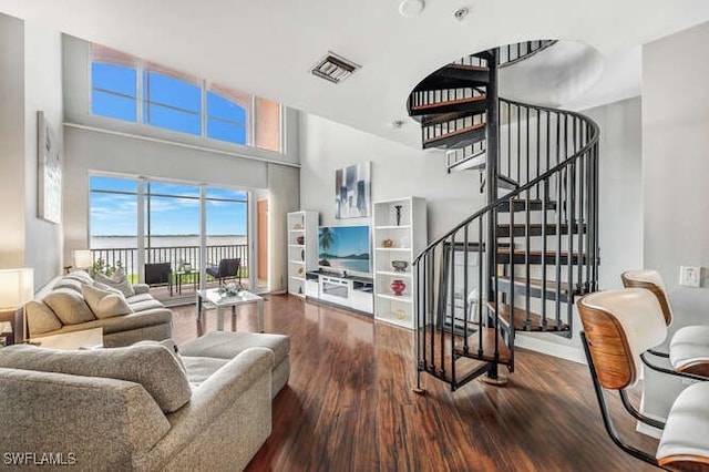 living room with wood-type flooring and a towering ceiling