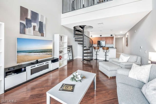 living room featuring dark hardwood / wood-style floors and a high ceiling