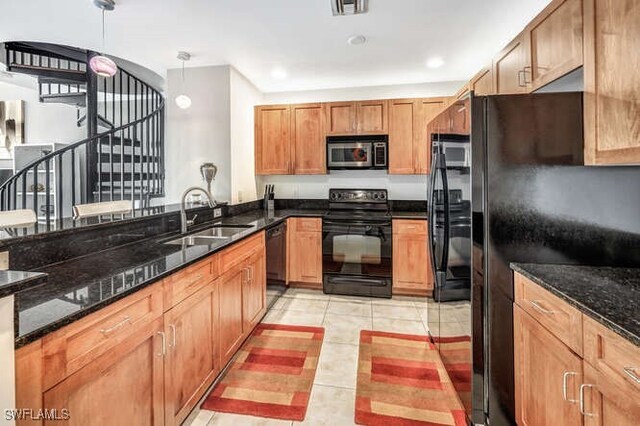 kitchen with sink, black appliances, pendant lighting, light tile patterned floors, and dark stone counters