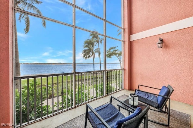 sunroom featuring a water view