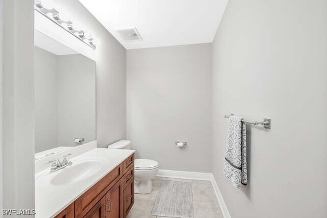 bathroom featuring toilet, vanity, and tile patterned floors