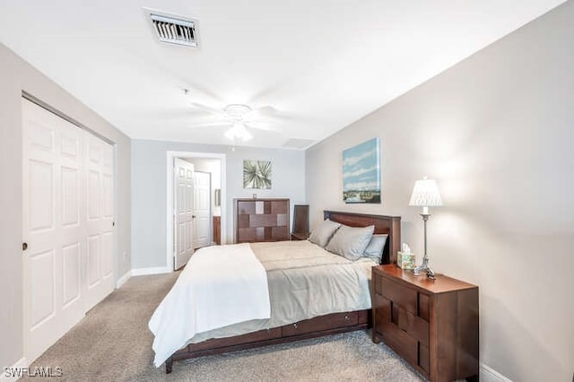 bedroom with a closet, ceiling fan, and light carpet