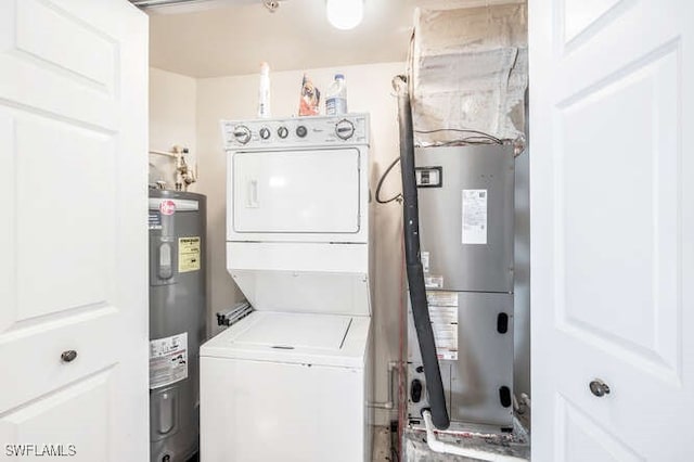 laundry room featuring stacked washer and dryer and electric water heater