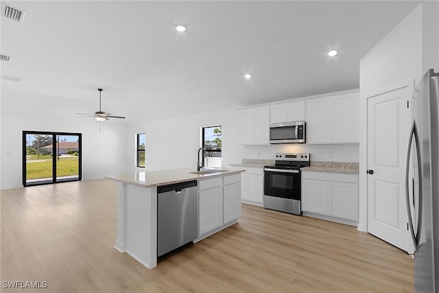 kitchen featuring stainless steel appliances, light wood-style flooring, a sink, a kitchen island with sink, and recessed lighting