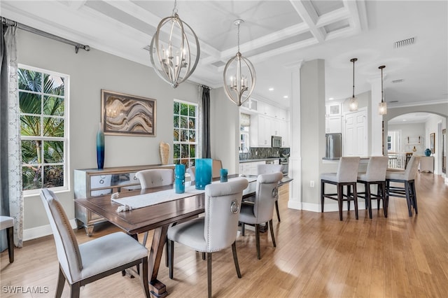 dining room with a healthy amount of sunlight, an inviting chandelier, light wood-type flooring, and coffered ceiling