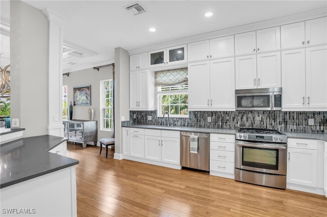 kitchen featuring stainless steel appliances, light hardwood / wood-style flooring, decorative backsplash, and white cabinets