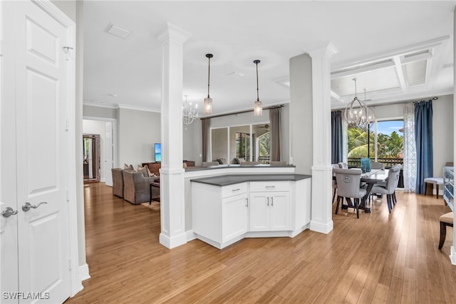 kitchen with light hardwood / wood-style flooring, pendant lighting, coffered ceiling, an inviting chandelier, and crown molding