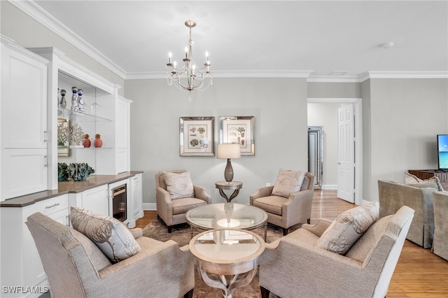 living room featuring light hardwood / wood-style floors, crown molding, and an inviting chandelier