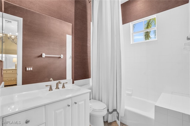 full bathroom with an inviting chandelier, toilet, shower / bath combo with shower curtain, and vanity