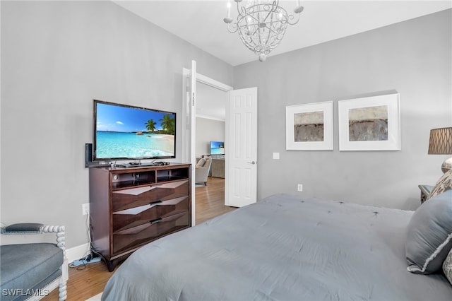 bedroom with a notable chandelier and hardwood / wood-style floors