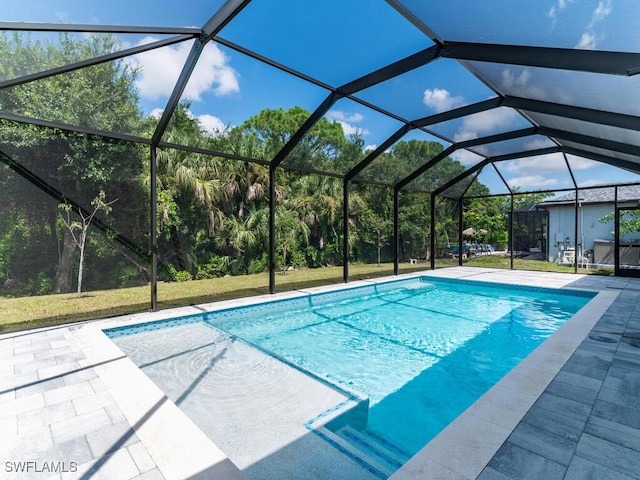 view of pool featuring a lawn, a patio area, and glass enclosure