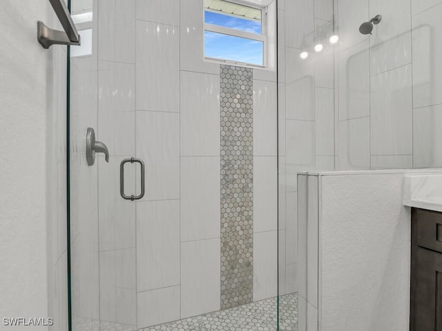 bathroom with a shower with door and vanity