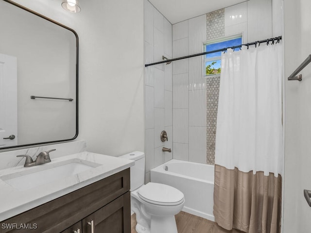 full bathroom featuring toilet, hardwood / wood-style floors, shower / bath combo with shower curtain, and vanity