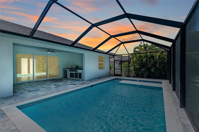 pool at dusk with grilling area, a patio, glass enclosure, and ceiling fan