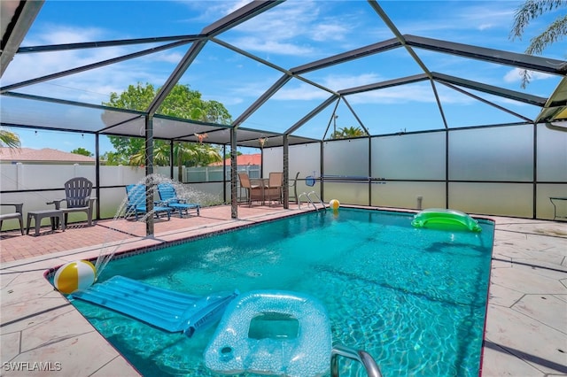 view of pool featuring glass enclosure and a patio