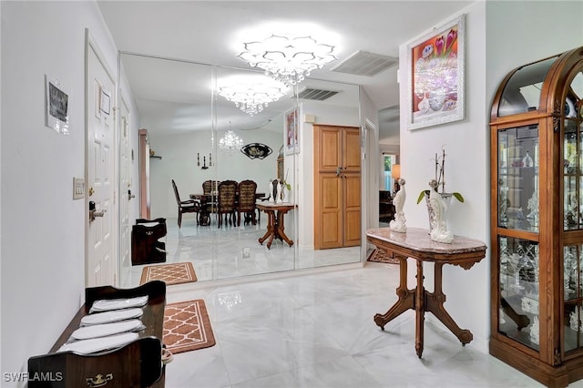 interior space with a notable chandelier and light tile patterned floors