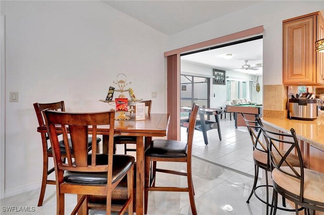 tiled dining space with ceiling fan and pool table