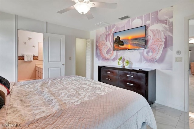 bedroom with ceiling fan, light tile patterned flooring, and ensuite bath