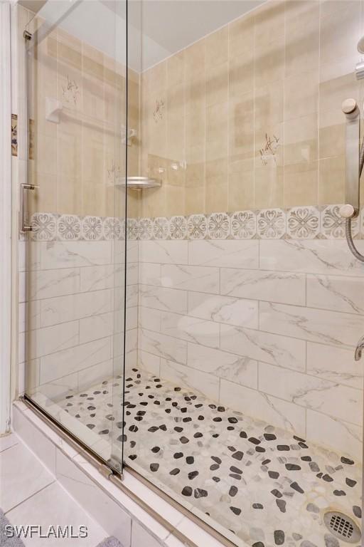 bathroom featuring tile patterned floors and a shower with shower door