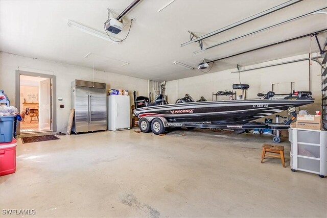 garage featuring a garage door opener, white refrigerator, and stainless steel built in refrigerator