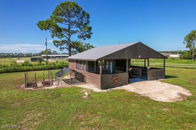 view of horse barn with a lawn and an outbuilding