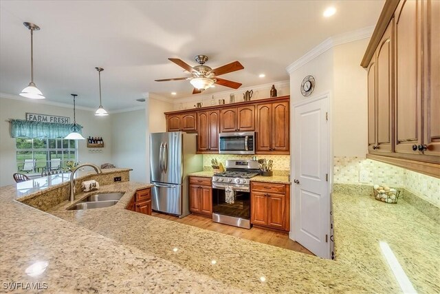 kitchen with stainless steel appliances, decorative backsplash, sink, light wood-type flooring, and pendant lighting