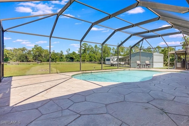 pool featuring a patio area, glass enclosure, and a yard