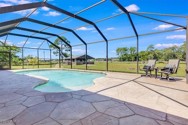 outdoor pool featuring glass enclosure, a patio area, and a yard