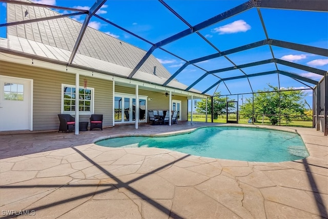 view of swimming pool with ceiling fan, a lanai, and a patio area