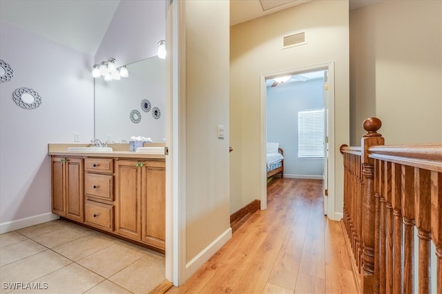 bathroom featuring wood-type flooring, vanity, and lofted ceiling