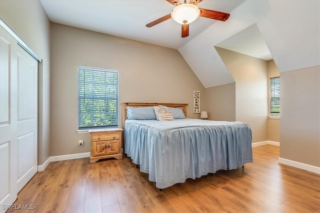 bedroom featuring vaulted ceiling, ceiling fan, light wood-type flooring, and baseboards