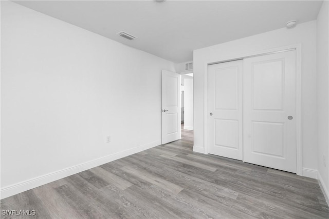 unfurnished bedroom featuring baseboards, visible vents, and light wood finished floors