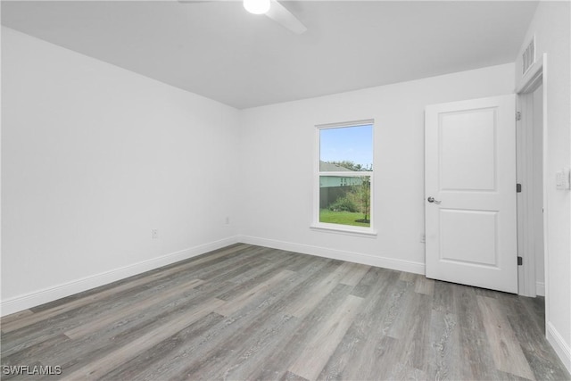 unfurnished room with light wood-type flooring, visible vents, and baseboards