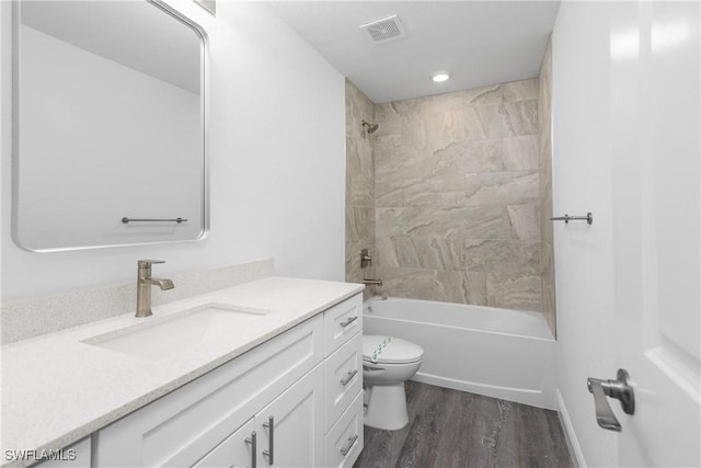 bathroom with bathtub / shower combination, toilet, wood finished floors, vanity, and visible vents