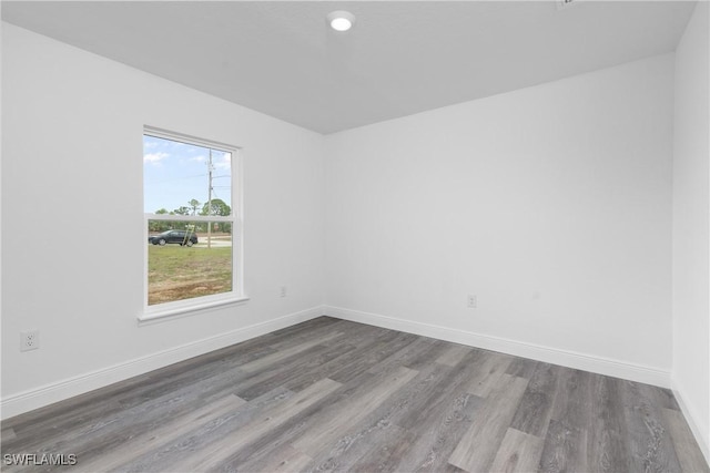 empty room featuring baseboards and wood finished floors