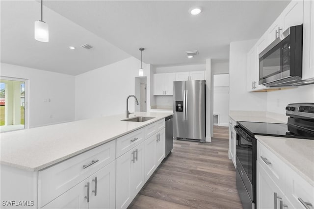 kitchen featuring stainless steel appliances, light countertops, white cabinets, and a sink