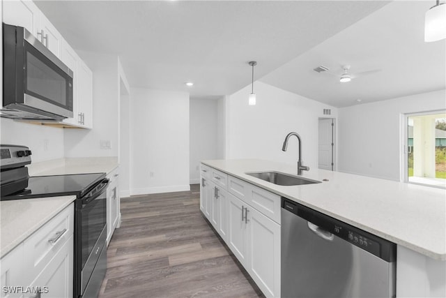 kitchen with appliances with stainless steel finishes, a sink, decorative light fixtures, and white cabinets