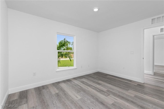 unfurnished room featuring light wood-style floors, visible vents, and baseboards