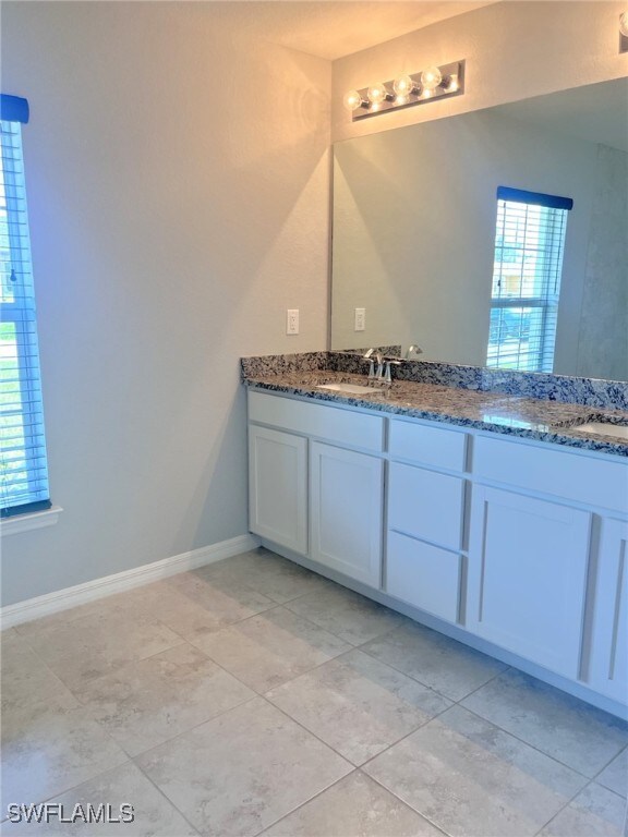 bathroom featuring dual bowl vanity and tile patterned floors