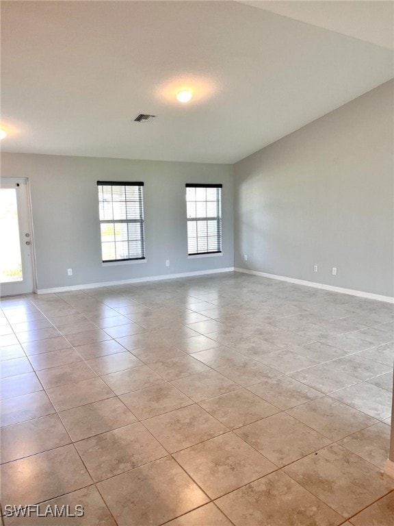 unfurnished room with a wealth of natural light and light tile patterned floors