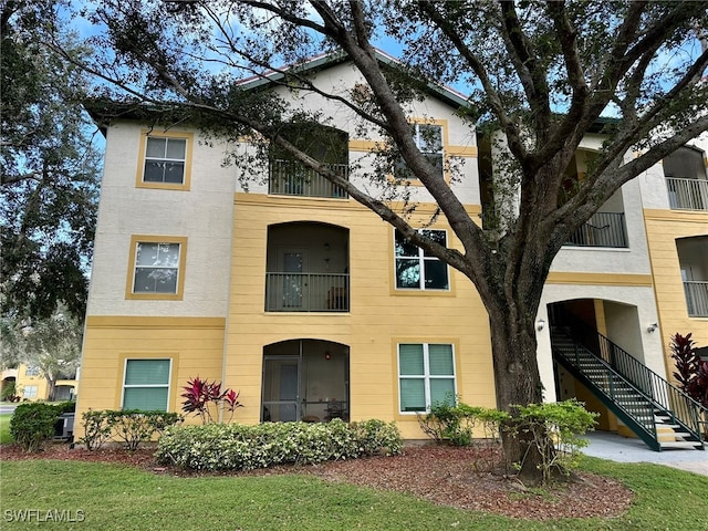 view of front of home with a front lawn and a balcony