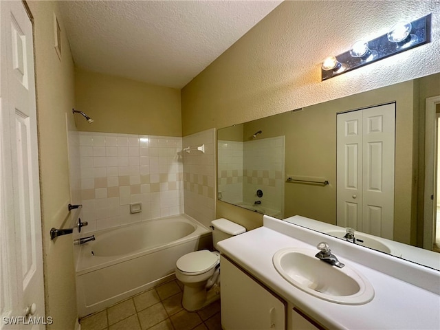 full bathroom with toilet, tile patterned flooring, tiled shower / bath combo, vanity, and a textured ceiling