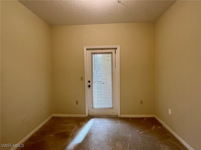 entryway with a textured ceiling and carpet flooring