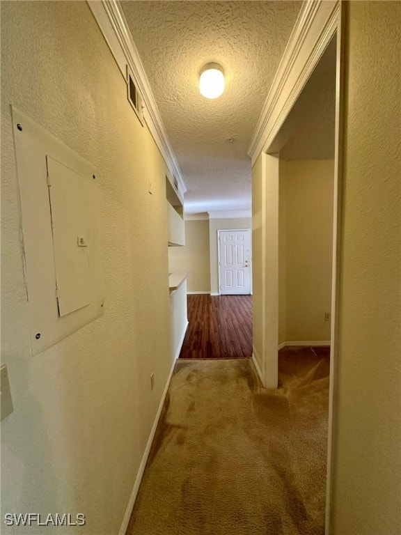 corridor with carpet, a textured ceiling, and ornamental molding