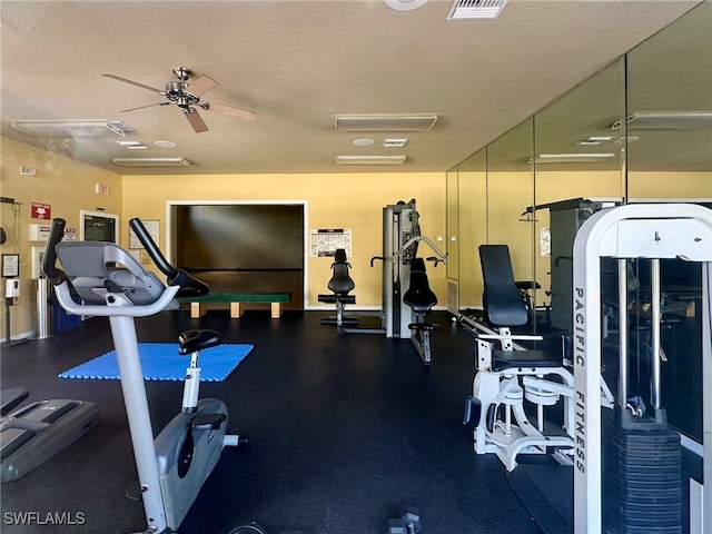 workout area with a textured ceiling and ceiling fan