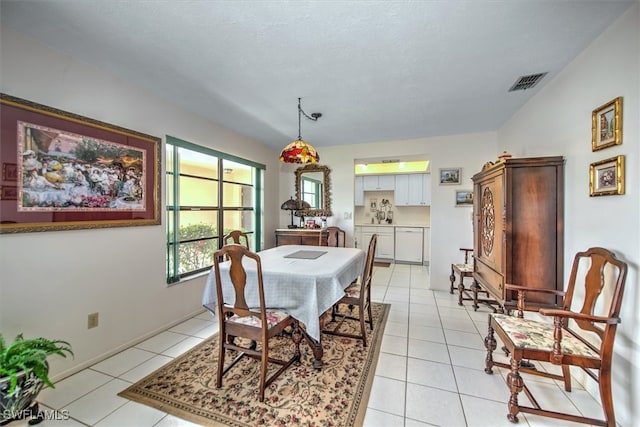 tiled dining room with a textured ceiling