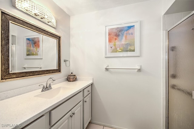 bathroom featuring a textured ceiling, an enclosed shower, vanity, and tile patterned flooring