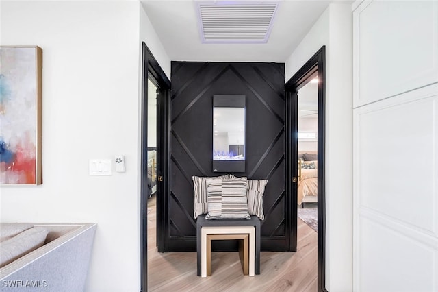 corridor featuring visible vents and light wood finished floors